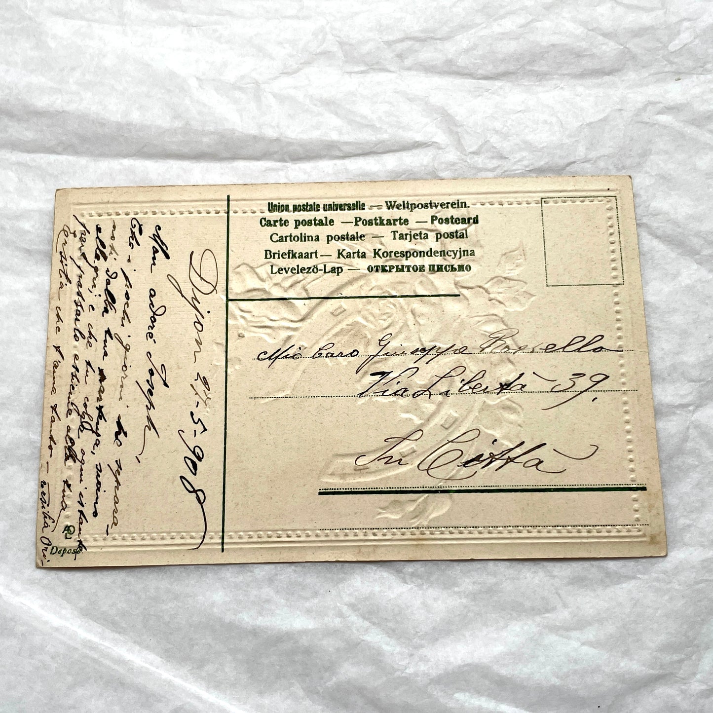 1900s French postcard with embossed pink roses and a green lucky horseshoe on a plaid background.