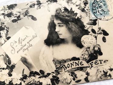 French postcard representing a young woman surrounded by flowers with the legend "Bonne fte" from 1900s