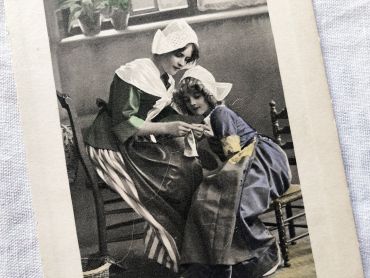 Vintage Belgian postcard representing a young girl and her mother teaching her to knit