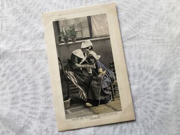 Vintage Belgian postcard representing a young girl and her mother teaching her to knit