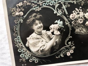 French postcard representing a young woman surrounded by flowers from 1900s