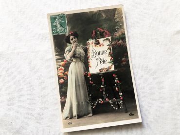 French postcard representing a young woman in front of an easel with the inscription "Bonne fête" from 1910s
