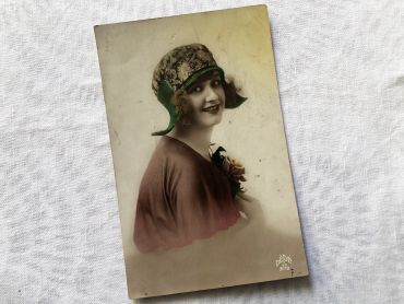 Vintage French postcard with a young woman with a typical Roaring Twenties hat from 1928