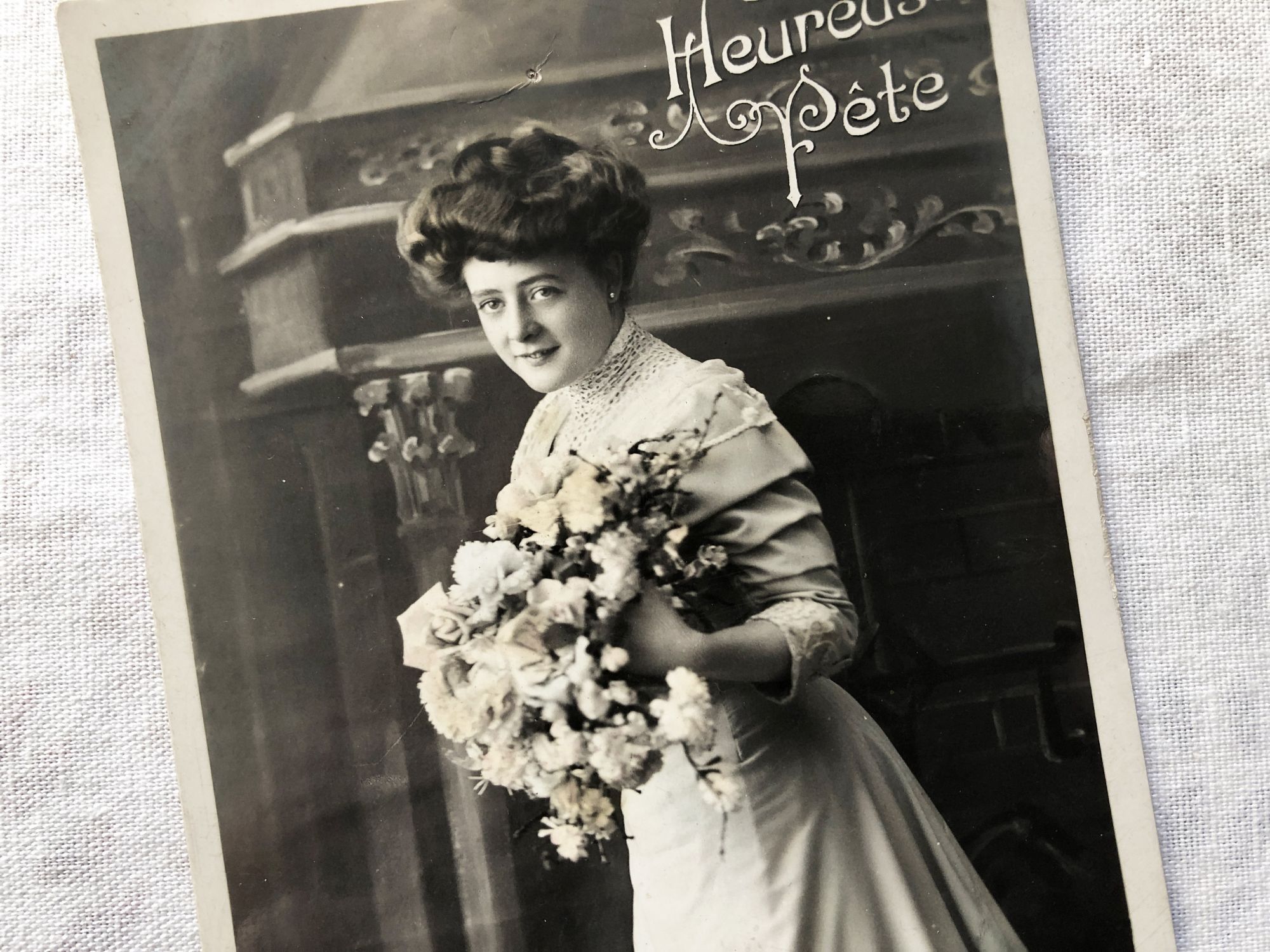 Vintage Belgian postcard representing a young woman with a bouquet of flowers