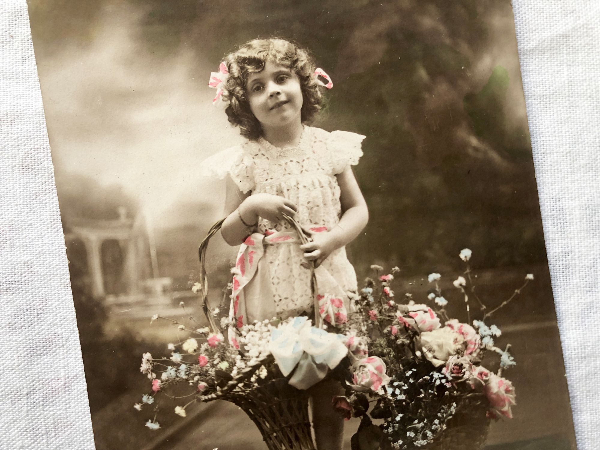 French vintage postcard representing a little girl with flowers from 1910s