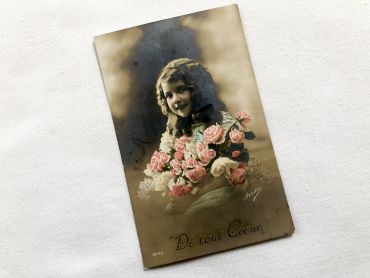 Vintage Belgian postcard with young girl with a bouquet of flowers from 1910