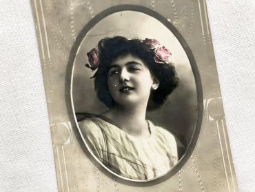 Swiss postcard of a young woman wearing flowers in her hair from 1900s