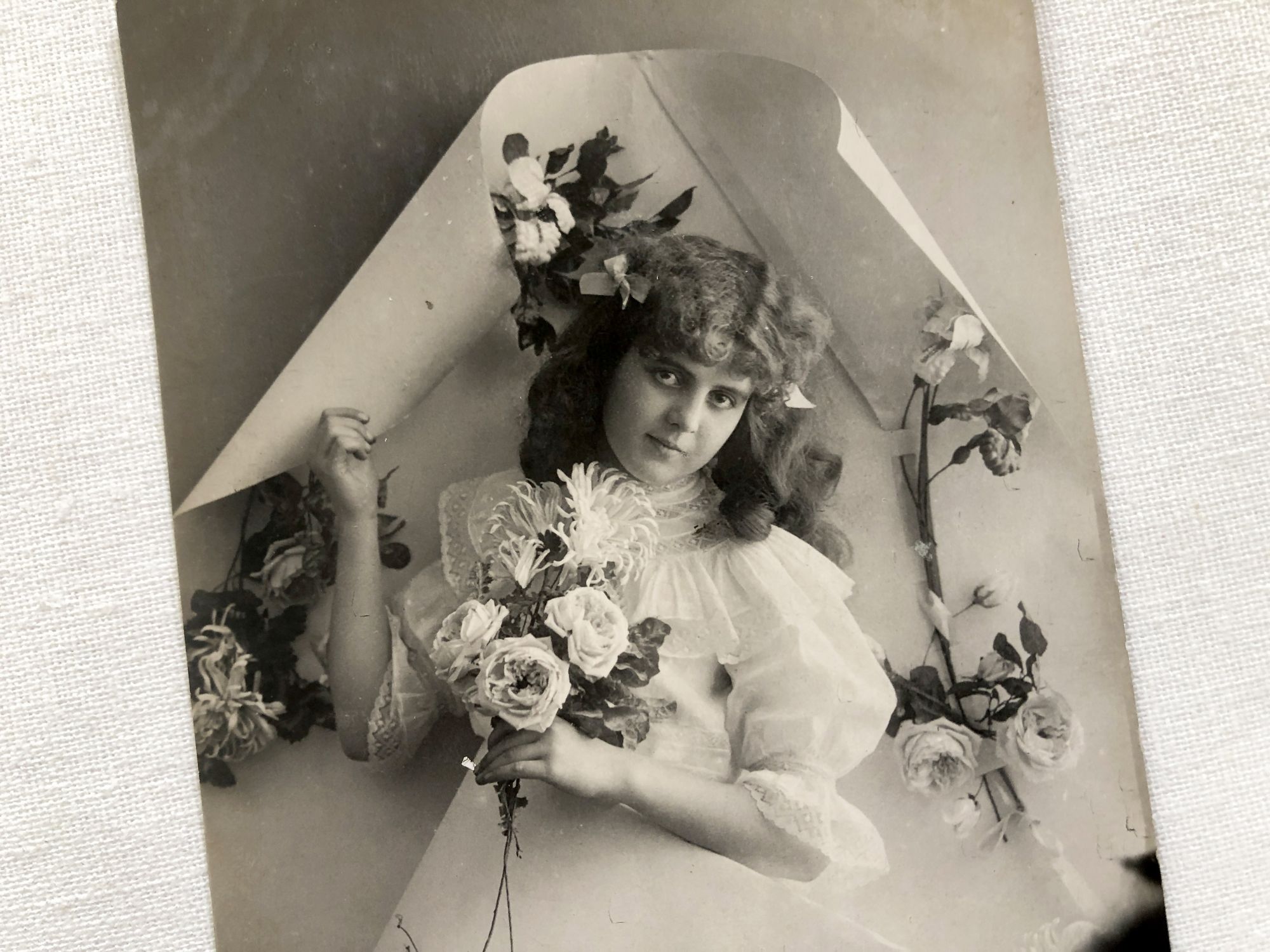 Vintage Belgian postcard with young girl with a bouquet of flowers from 1900s