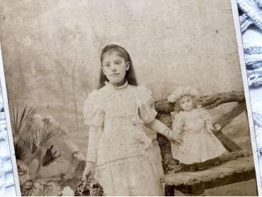 Old French photograph of a girl and her doll made by the photographer Numa Blanc (father) circa 1879