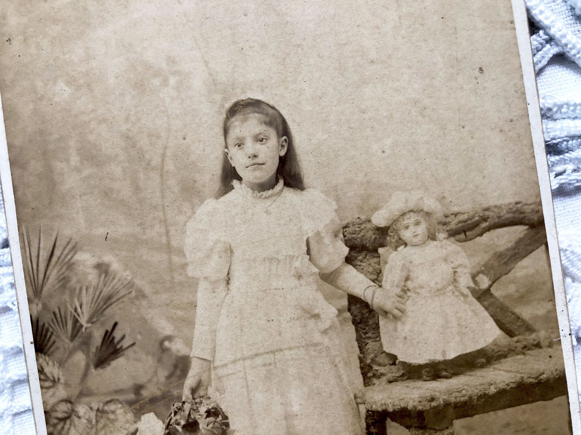 Old French photograph of a girl and her doll made by the photographer Numa Blanc (father) circa 1879