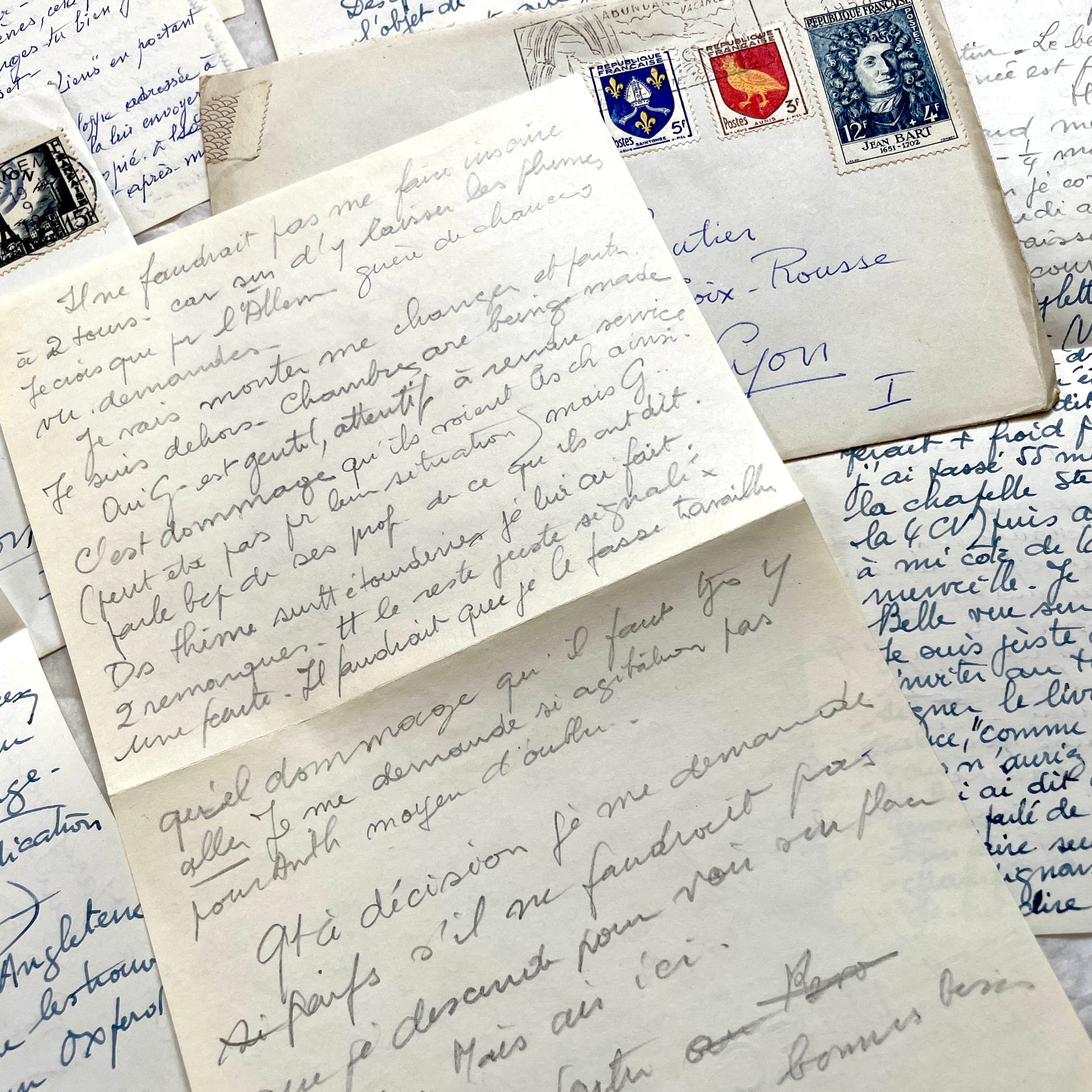 Set of 1950s French handwritten letters and envelopes with stamps. Vintage paper ephemera for collectors.