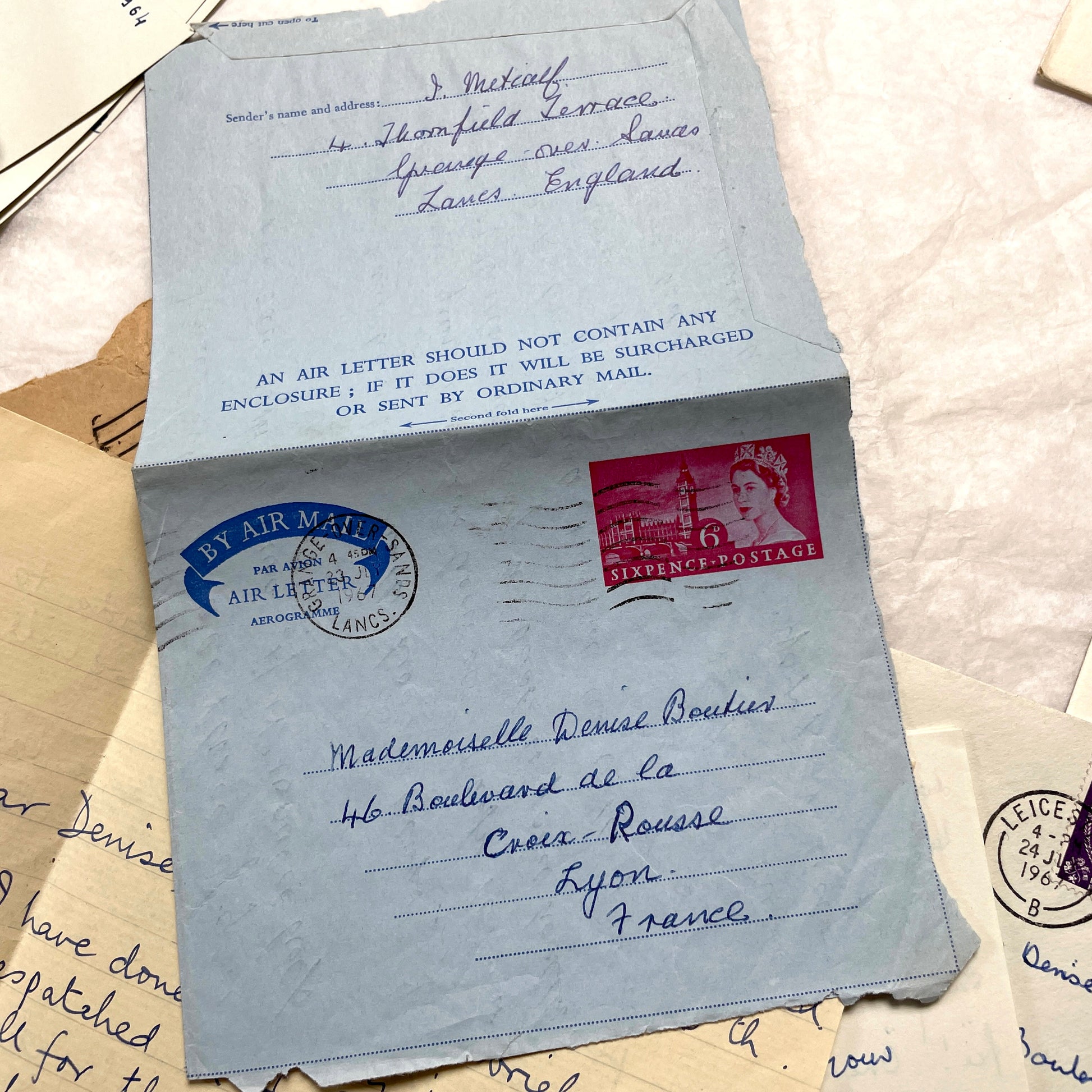 Set of 1960s handwritten letters and envelopes with vintage stamps and postmarks, displaying English and French text.