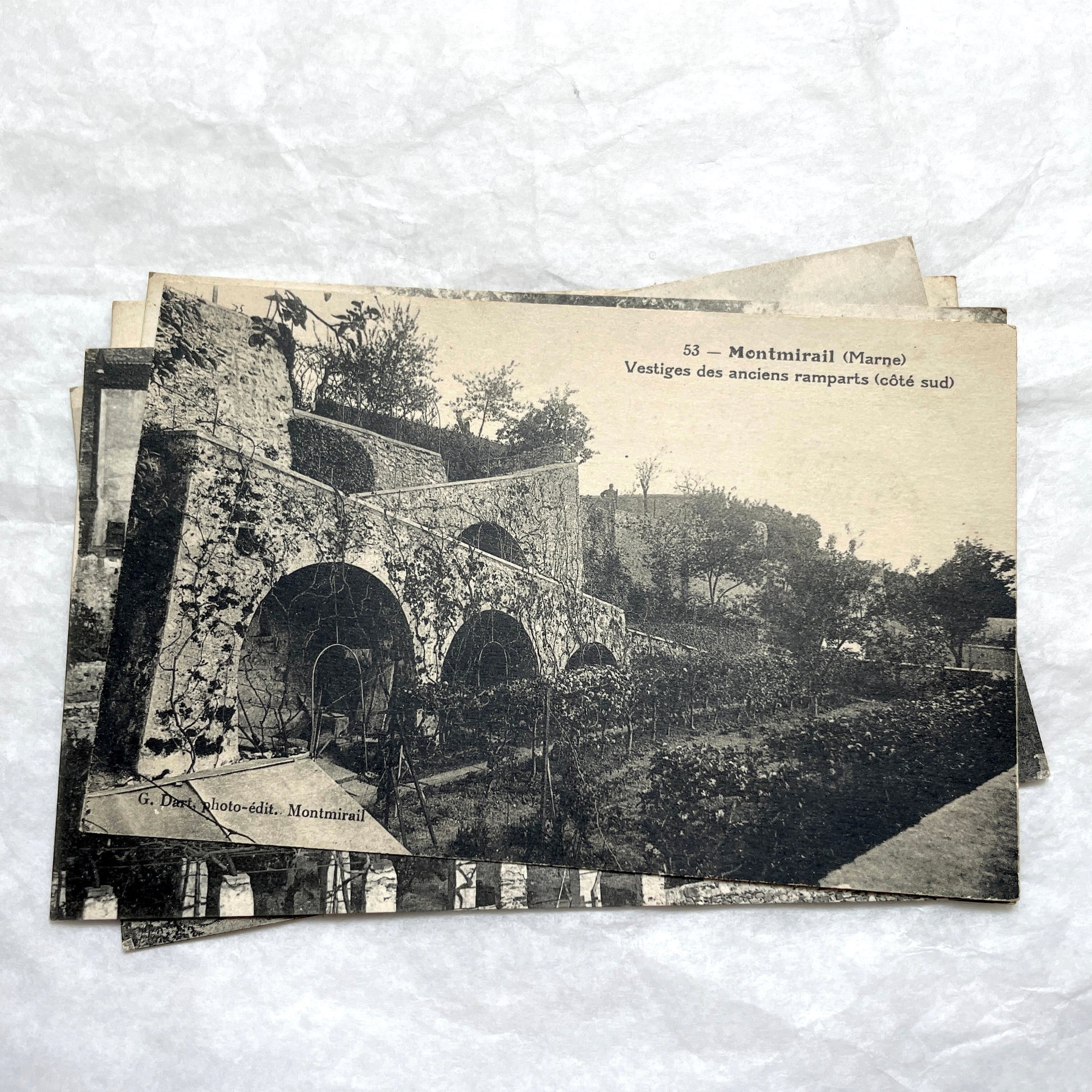 Lot of 1910s French postcards showing historic village scenes, old ramparts, a bridge, and a tower in France.