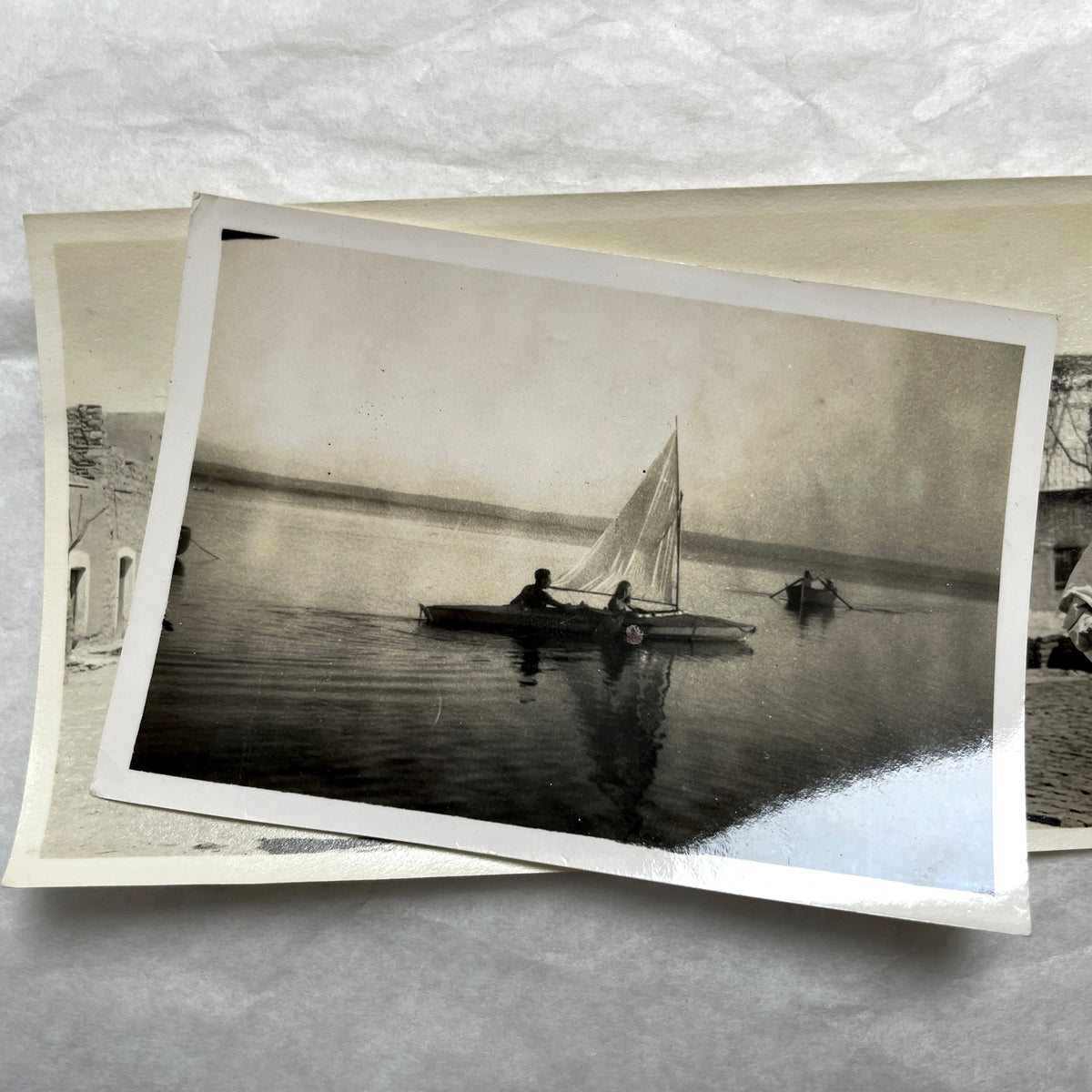 Lot of 1940s vintage photographs showing people skiing, a camel rider, an ocean scene with a military man, and a dog.