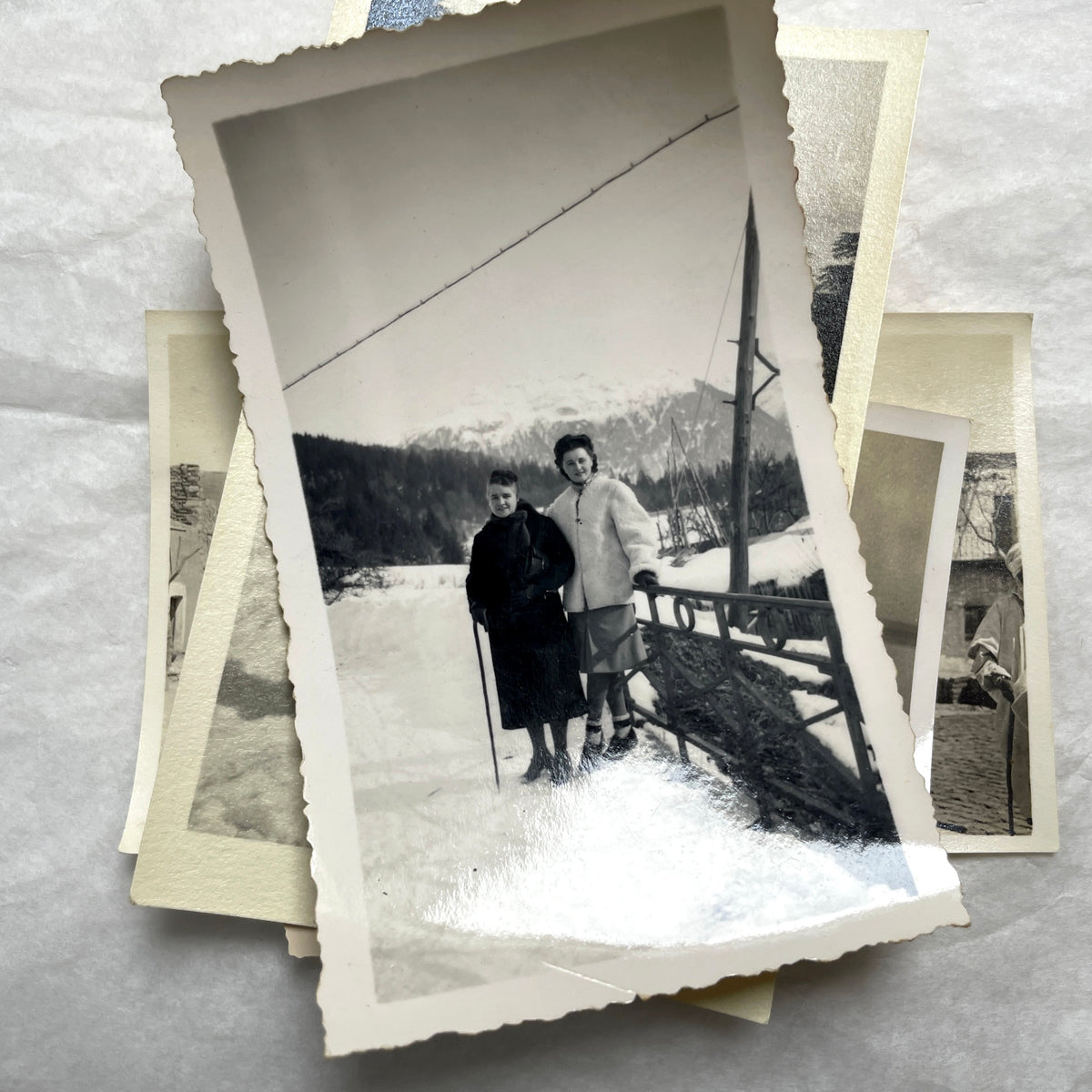 Lot of 1940s vintage photographs showing people skiing, a camel rider, an ocean scene with a military man, and a dog.
