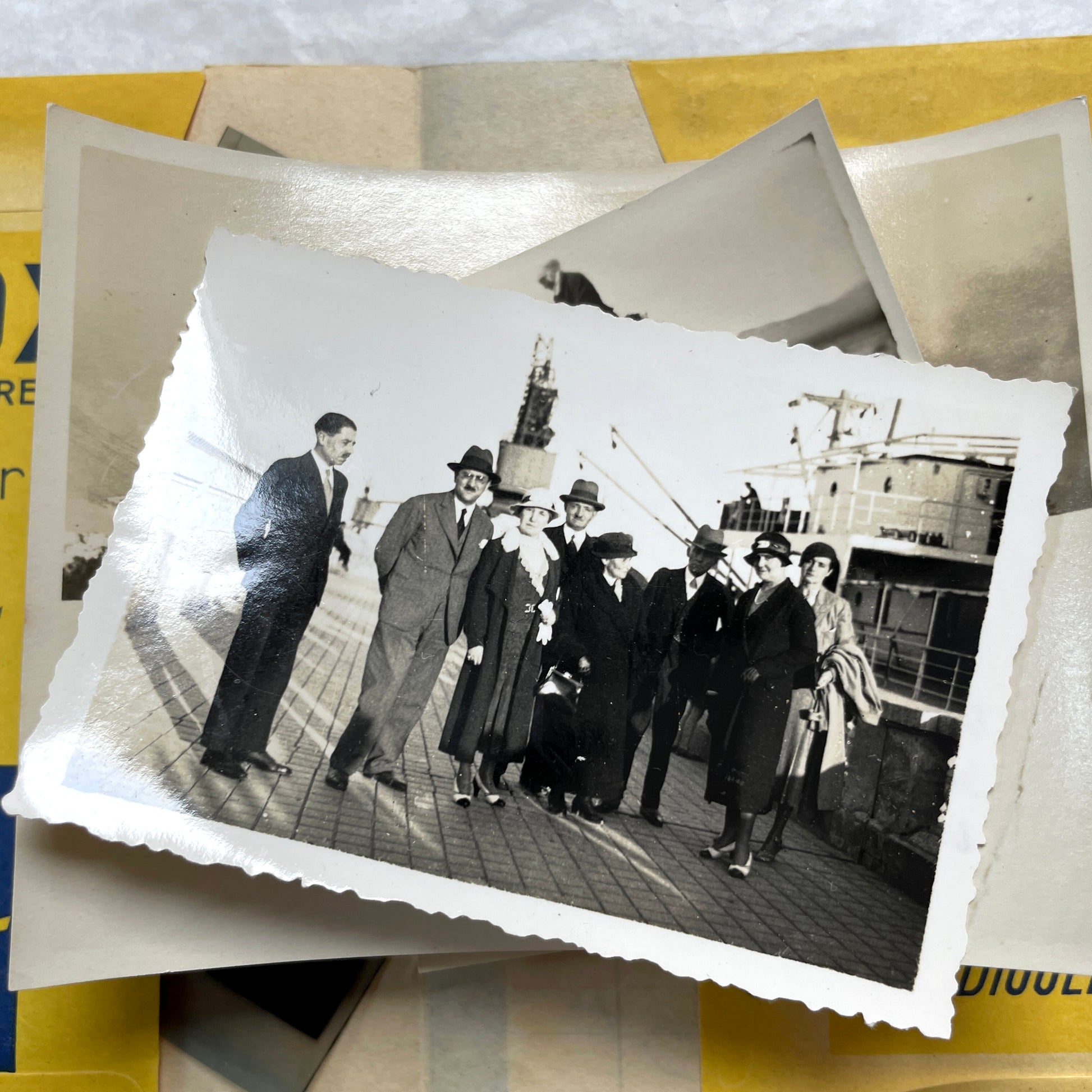 1920s vintage photograph lot showing people skiing in mountains, riding camels in the desert, and gathered on a ship deck.