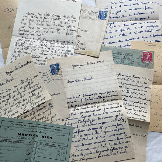 Five 1950s French handwritten letters with envelopes, showing vintage stamps and unique cursive script.