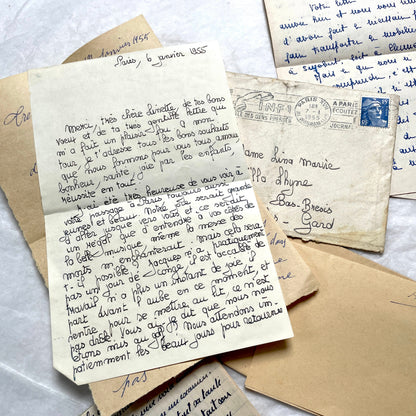 Five 1950s French handwritten letters with envelopes, showing vintage stamps and unique cursive script.