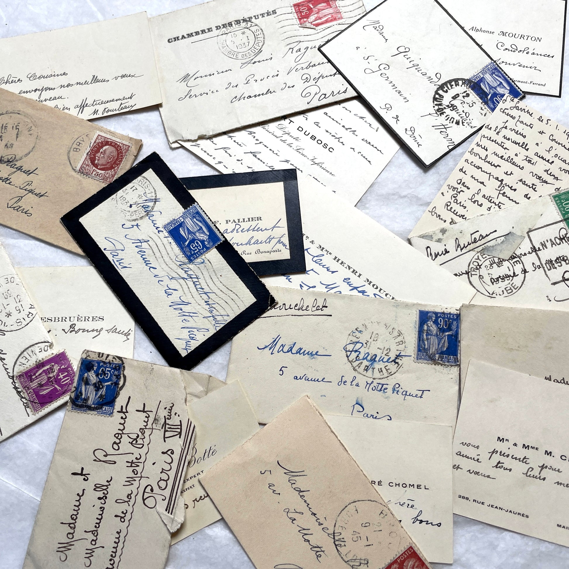 Lot of 10 French 1930s miniature envelopes with handwritten notes, business cards, and vintage stamps.