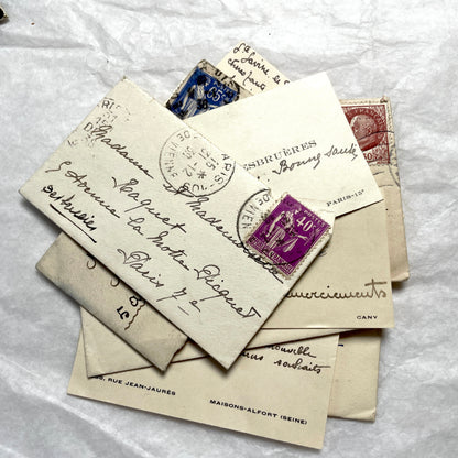Lot of 10 French 1930s miniature envelopes with handwritten notes, business cards, and vintage stamps.