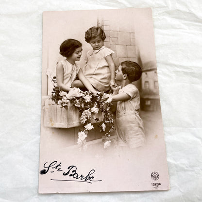 1920s - Charming Vintage Postcard - Three Children with Flowers - Sentimental Ephemera - Ste Barbe Dedication - Collectible Historical Piece