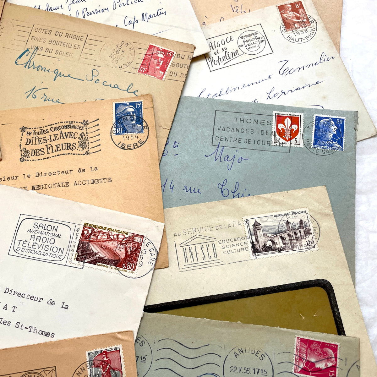 Lot of 20 French envelopes from the 1950s featuring various vintage stamps, postmarks, and handwritten addresses.