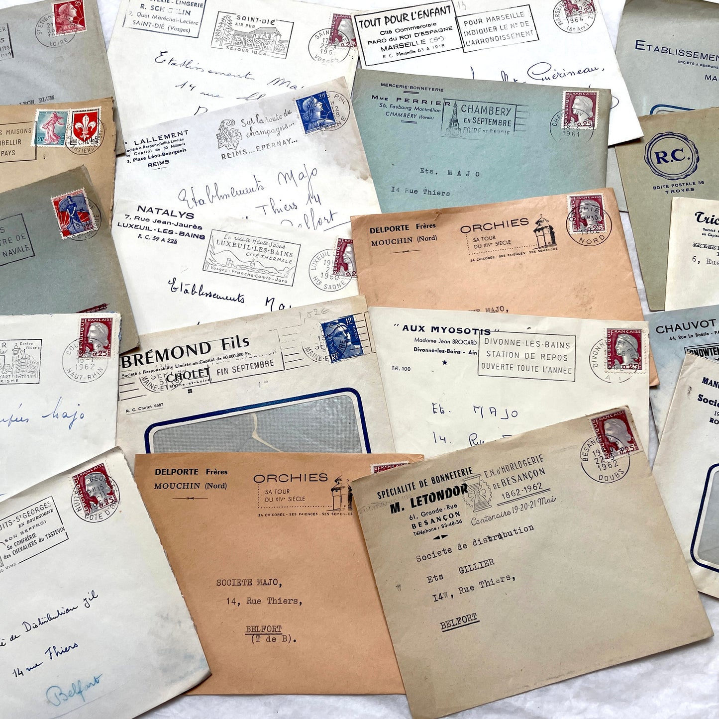 1960s French envelope lot featuring various postmarks, vintage stamps, and printed company addresses.
