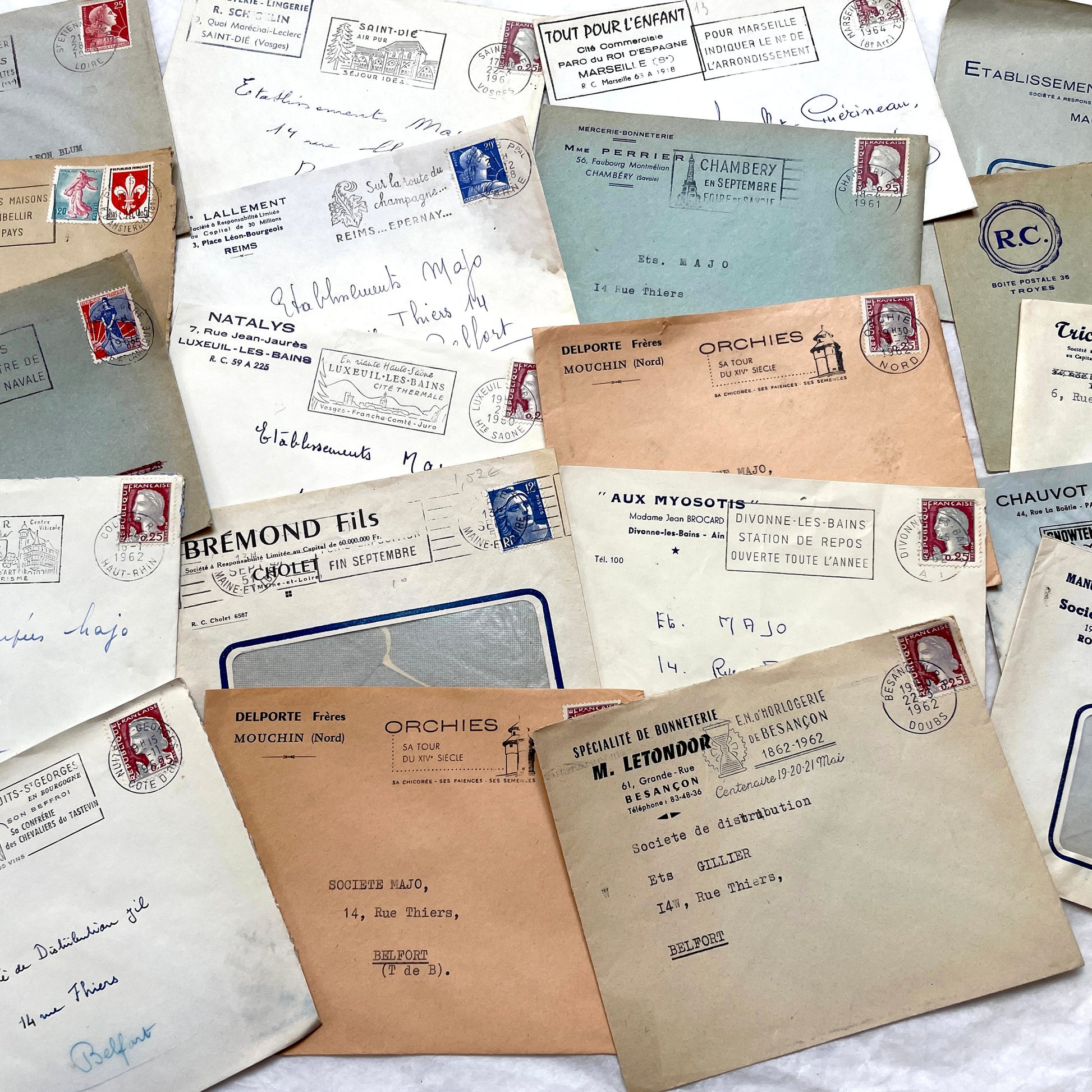 1960s French envelope lot featuring various postmarks, vintage stamps, and printed company addresses.