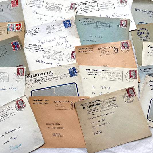 1960s French envelope lot featuring various postmarks, vintage stamps, and printed company addresses.