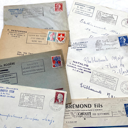 1960s French envelope lot featuring various postmarks, vintage stamps, and printed company addresses.
