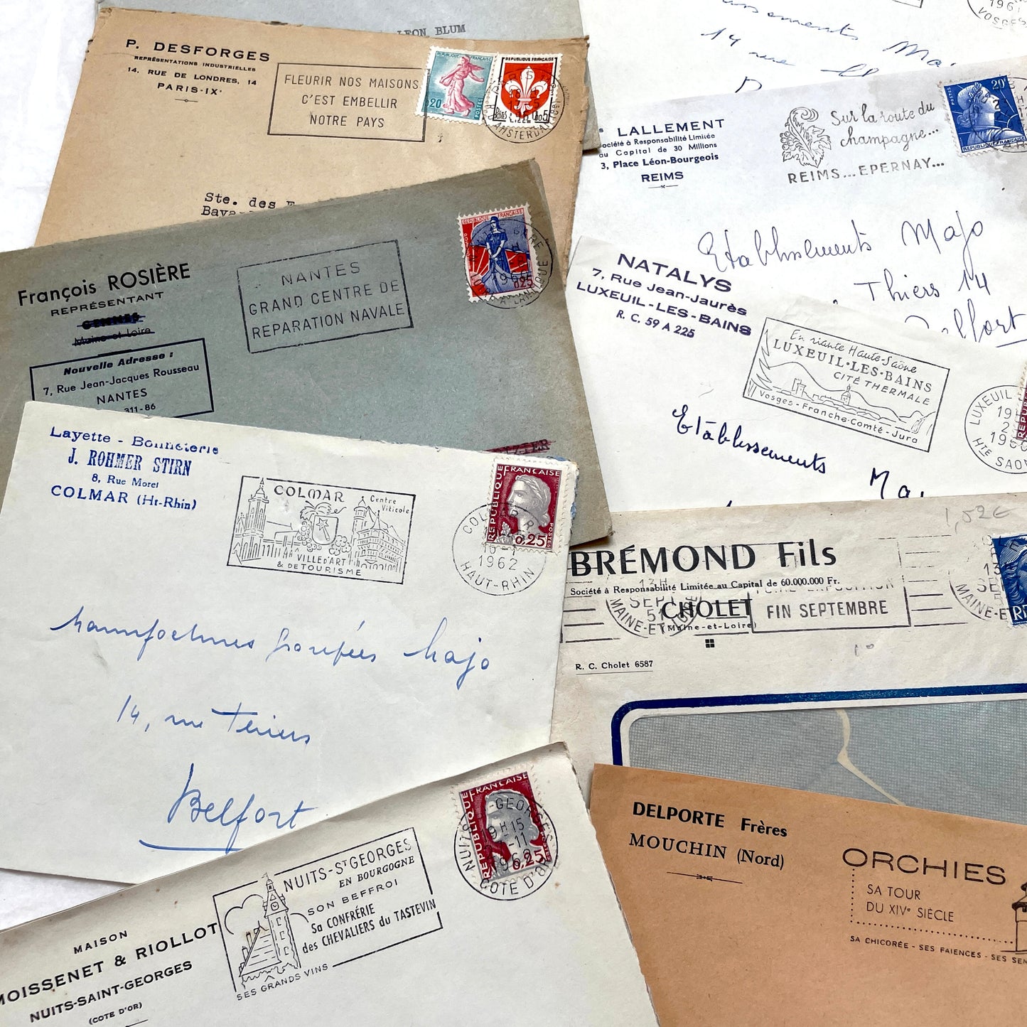 1960s French envelope lot featuring various postmarks, vintage stamps, and printed company addresses.