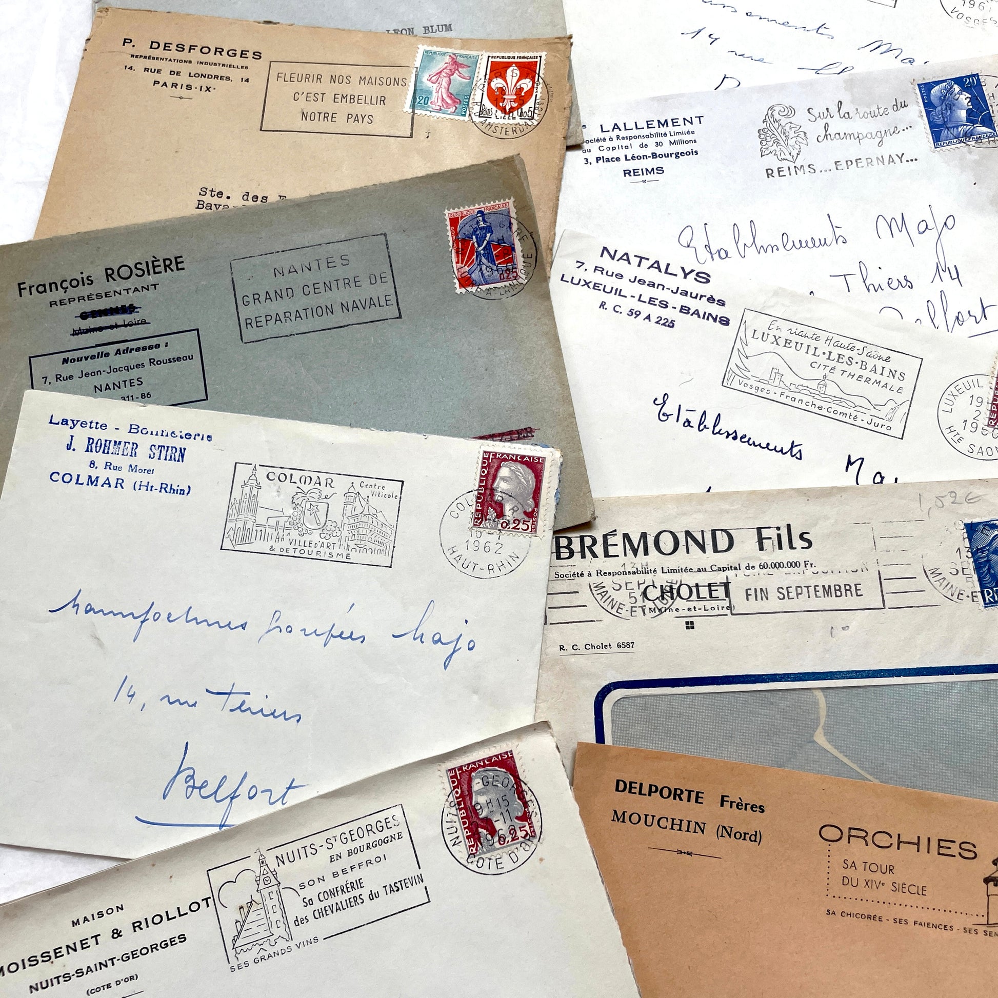 1960s French envelope lot featuring various postmarks, vintage stamps, and printed company addresses.