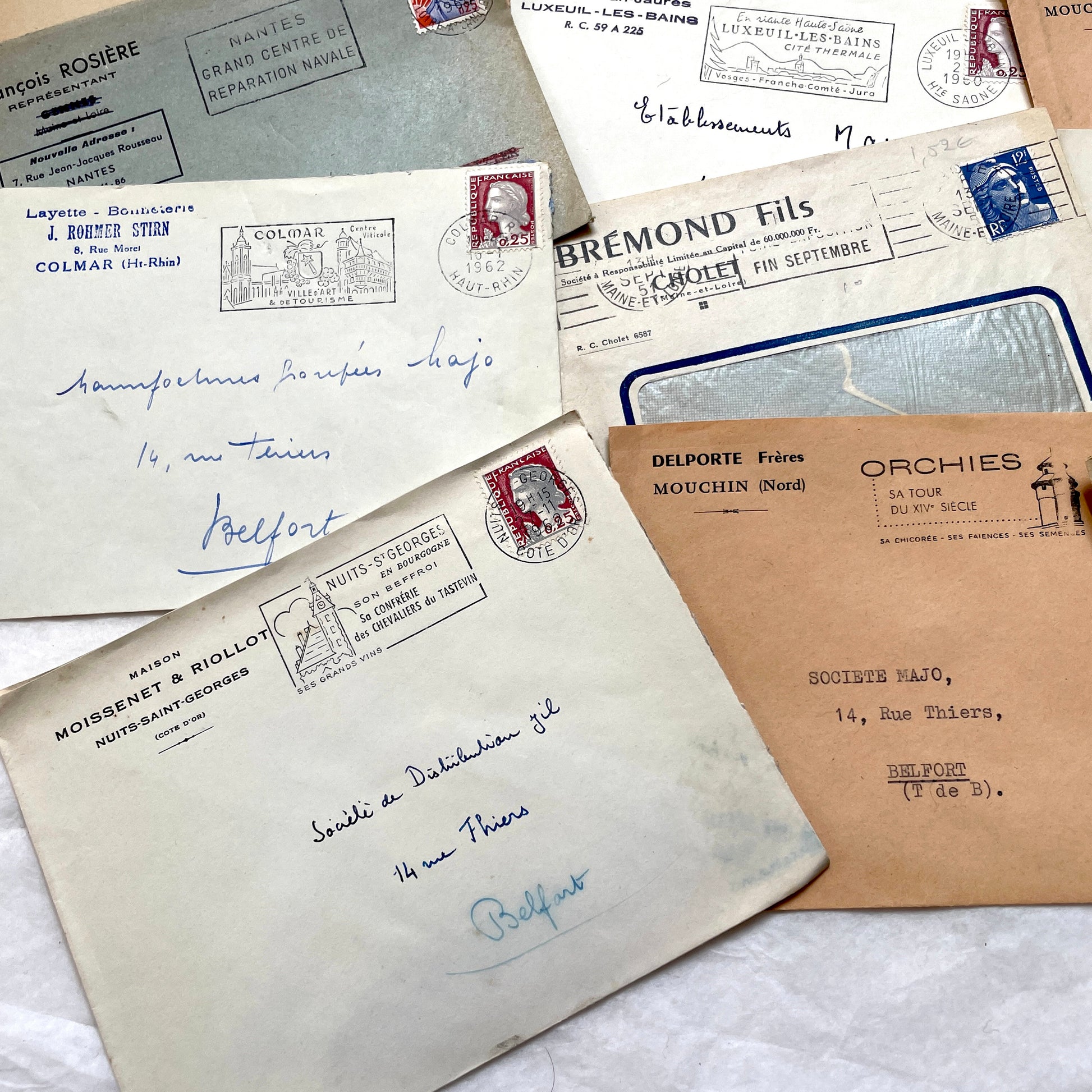 1960s French envelope lot featuring various postmarks, vintage stamps, and printed company addresses.