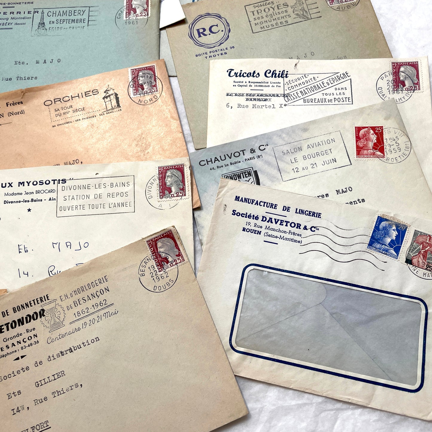 1960s French envelope lot featuring various postmarks, vintage stamps, and printed company addresses.