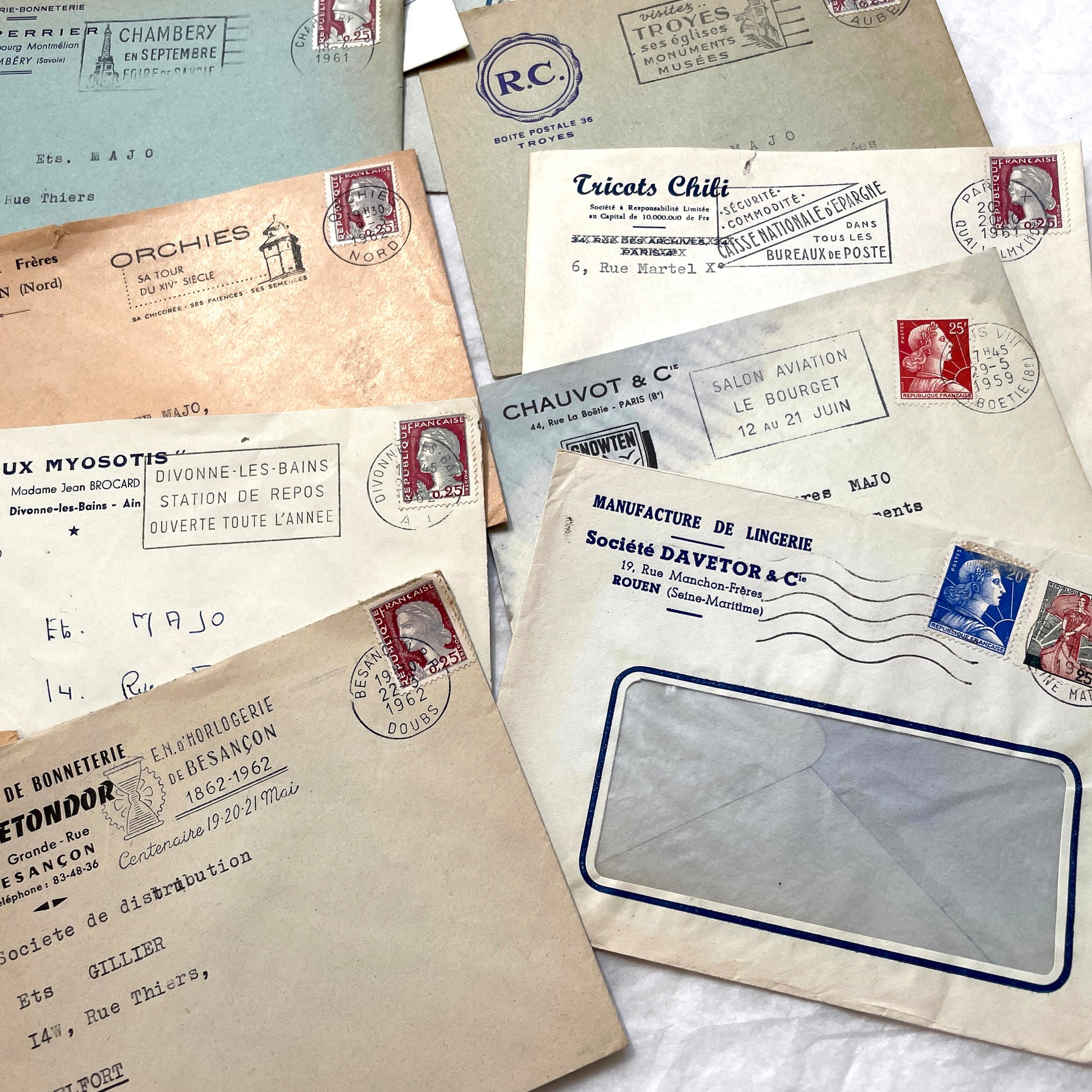 1960s French envelope lot featuring various postmarks, vintage stamps, and printed company addresses.