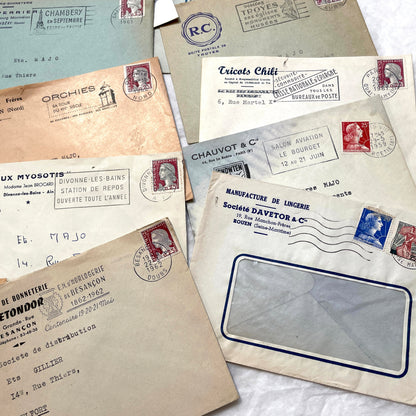 1960s French envelope lot featuring various postmarks, vintage stamps, and printed company addresses.