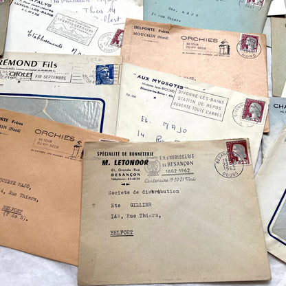 1960s French envelope lot featuring various postmarks, vintage stamps, and printed company addresses.