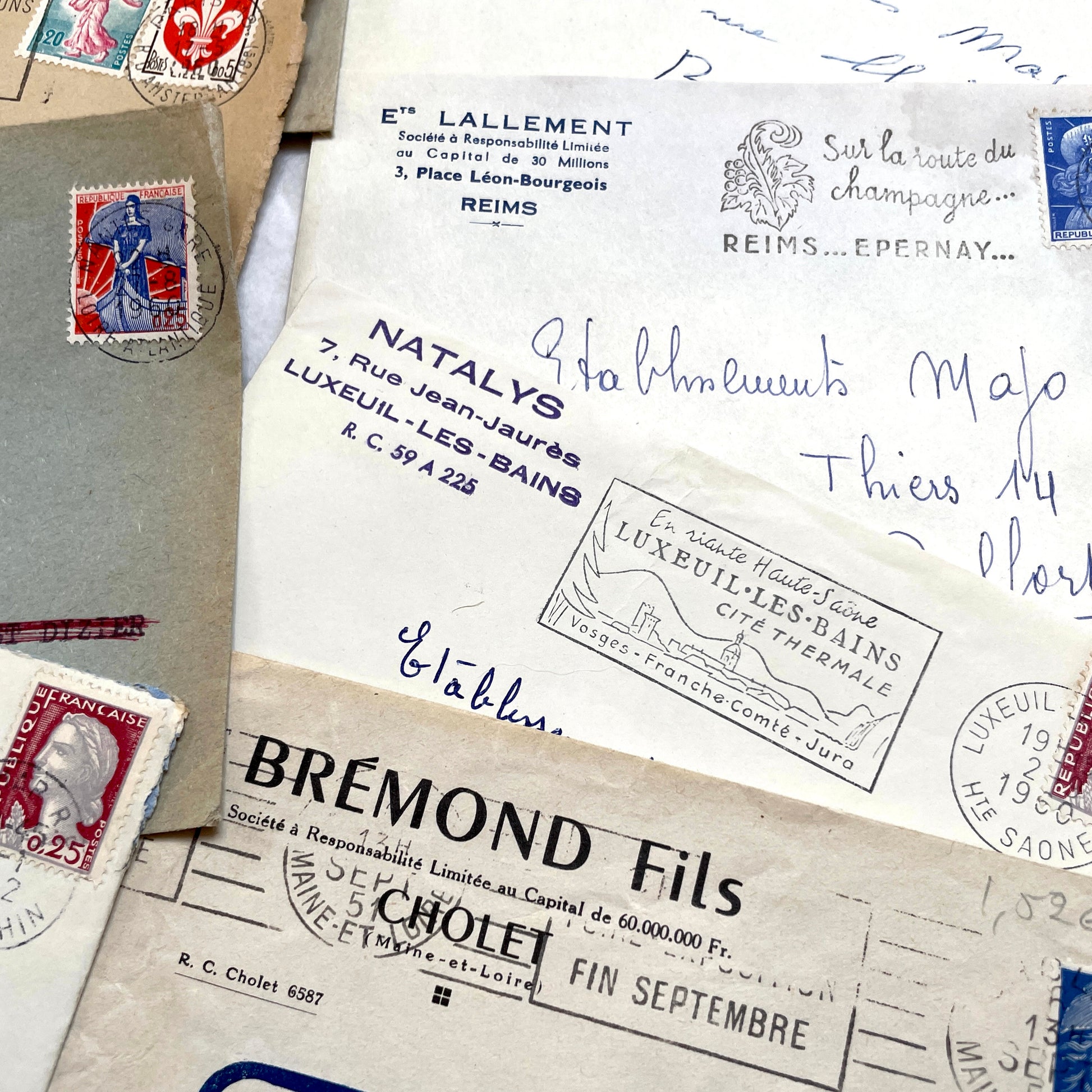 1960s French envelope lot featuring various postmarks, vintage stamps, and printed company addresses.
