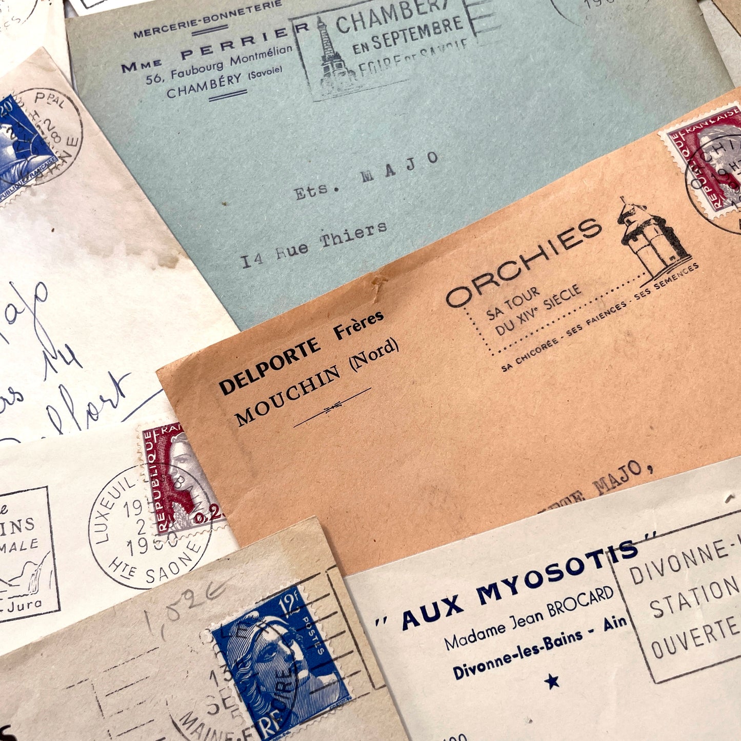 1960s French envelope lot featuring various postmarks, vintage stamps, and printed company addresses.