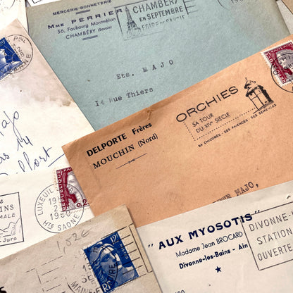 1960s French envelope lot featuring various postmarks, vintage stamps, and printed company addresses.