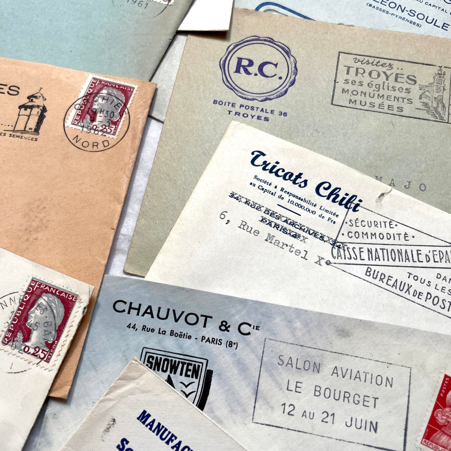 1960s French envelope lot featuring various postmarks, vintage stamps, and printed company addresses.