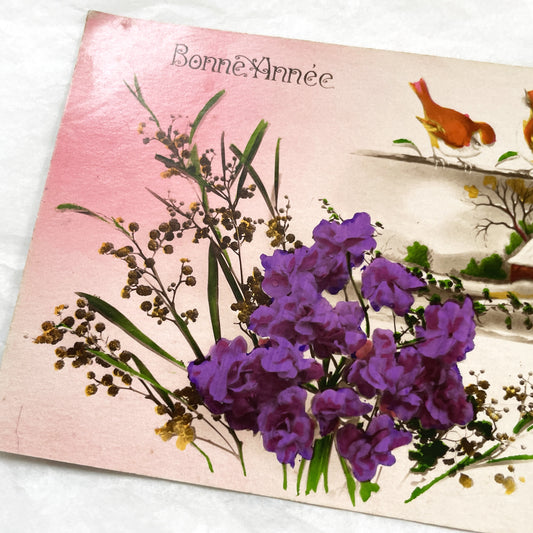 1910s - French New Year Postcard - Vintage Winter Scene with Birds and Snow-Covered Cottage - Vibrant Purple Flowers - Greeting Card