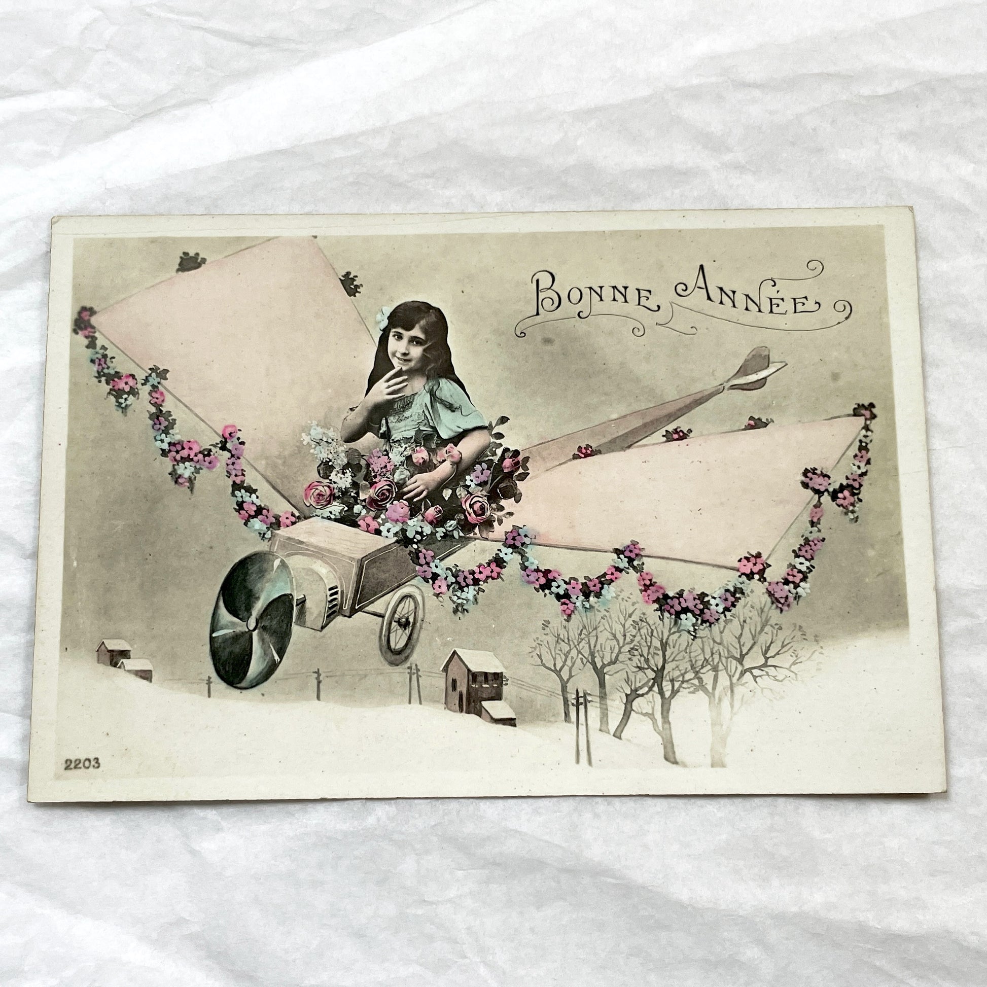 1910s - Vintage French New Year Postcard - Whimsical Little Girl Flying Flower-Adorned Biplane - Unique Early Aviation Themed Greeting Card