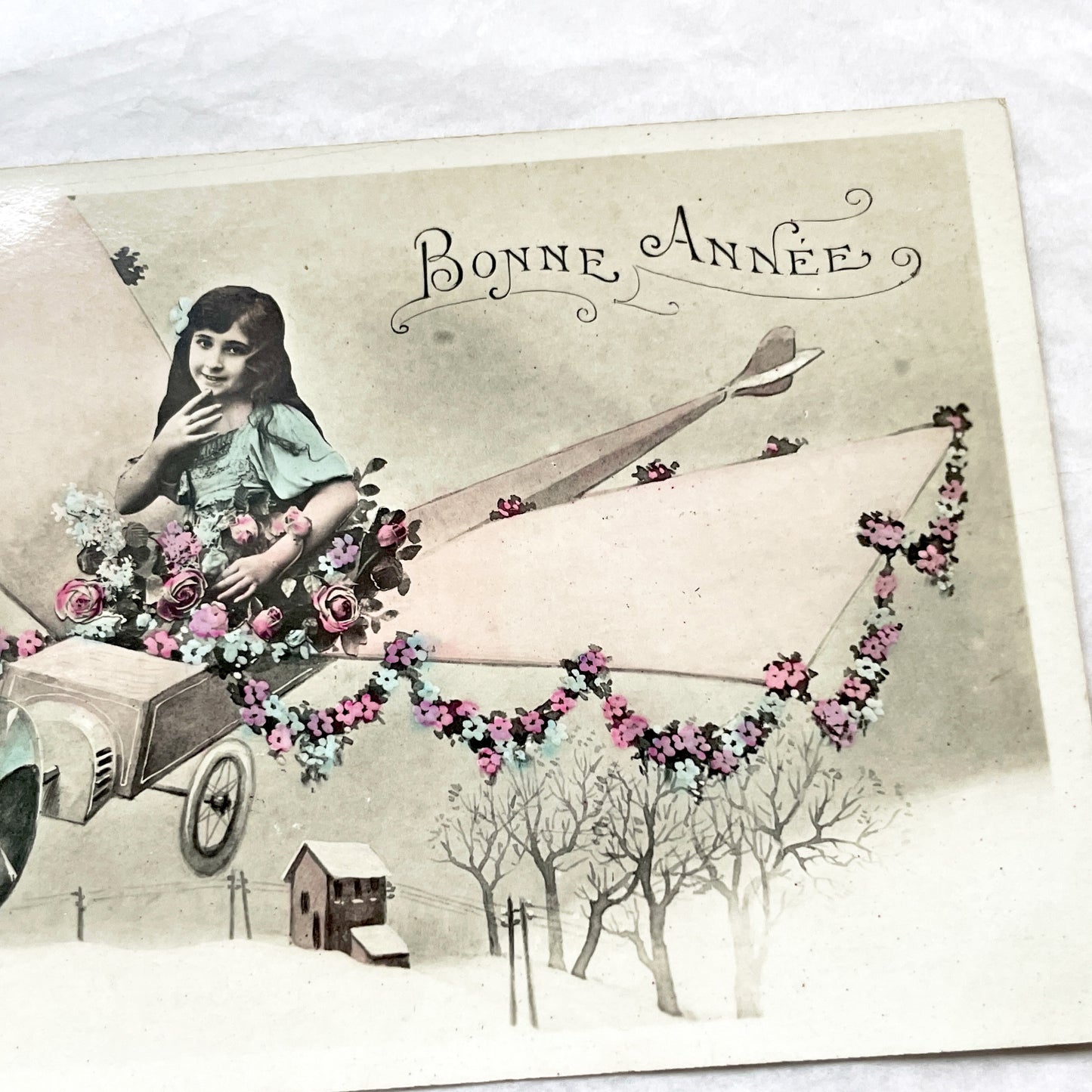 1910s - Vintage French New Year Postcard - Whimsical Little Girl Flying Flower-Adorned Biplane - Unique Early Aviation Themed Greeting Card