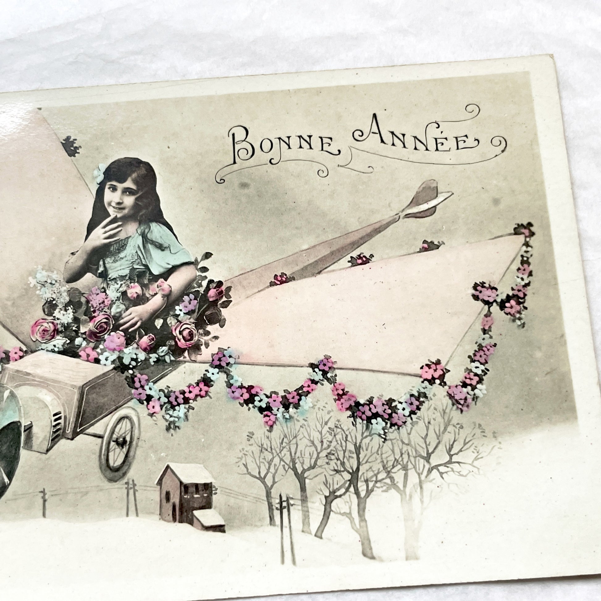 1910s - Vintage French New Year Postcard - Whimsical Little Girl Flying Flower-Adorned Biplane - Unique Early Aviation Themed Greeting Card