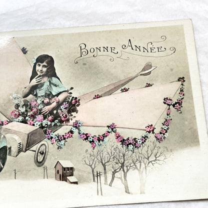1910s - Vintage French New Year Postcard - Whimsical Little Girl Flying Flower-Adorned Biplane - Unique Early Aviation Themed Greeting Card