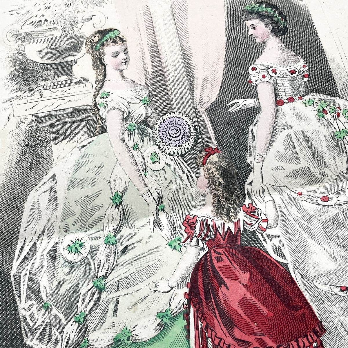 1860s French fashion plate depicting two women in elaborate ball gowns and a child in a red and white striped dress.