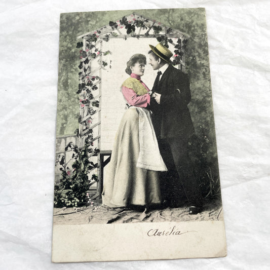 1900s - Vintage Hand-Tinted Postcard - Romantic Couple Under Arbor - 'Aurelia' Caption - Edwardian Era Lovers - Antique Collectible