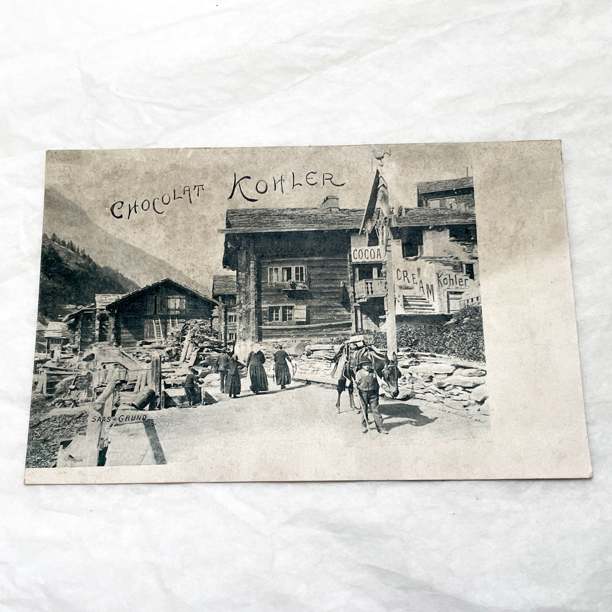 1900s - Vintage Swiss Saas-Grund Village Scene Postcard with Chocolat Kohler Advertising and Alpine Lifestyle - Collectible Ephemera.