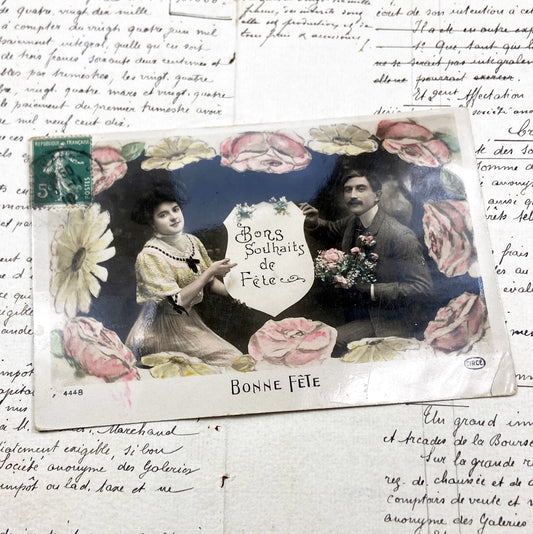 1910s - Hand-Colored French Postcard “Bonne Fête” – Early 20th Century Floral Border with Seated Couple and Festive Wishes